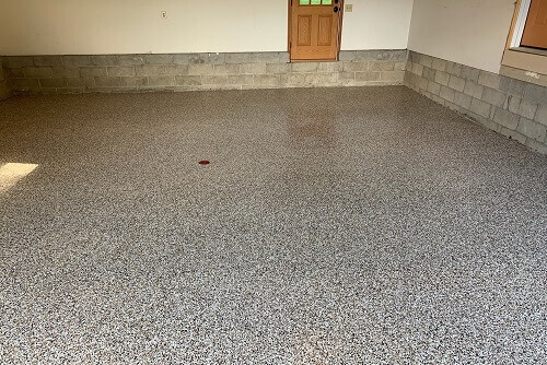 Finished concrete floor with a polyaspartic protective coating